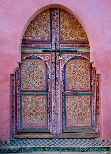 Traditional carved and painted wooden door in a Marrakech riad courtyard